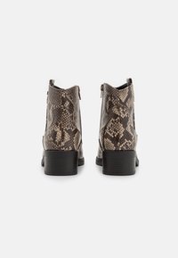 Bottines en cuir lisse imprimé serpent marron, avec un petit talon empilé et une fermeture éclair à l'arrière.