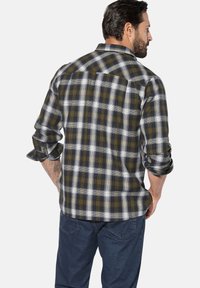 Herren-Karohemd in Marineblau, Grau und Grüntönen, mit knopflosen Manschetten und einer Rückenpasse. Hergestellt aus Flanellstoff mit strukturierter Oberfläche.