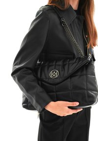 Borsa a tracolla nera in pelle trapuntata con patta pieghevole, dettaglio con logo argento e una tracolla a catena. Texture liscia e forma strutturata.