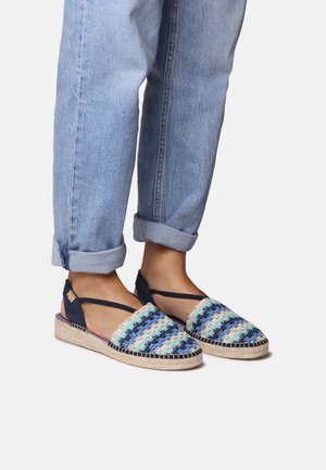 Espadriller i espadrille-stil med vævet stof i flere farver i blå, grøn og creme, med en jutesål og krydsede ankelstropper.