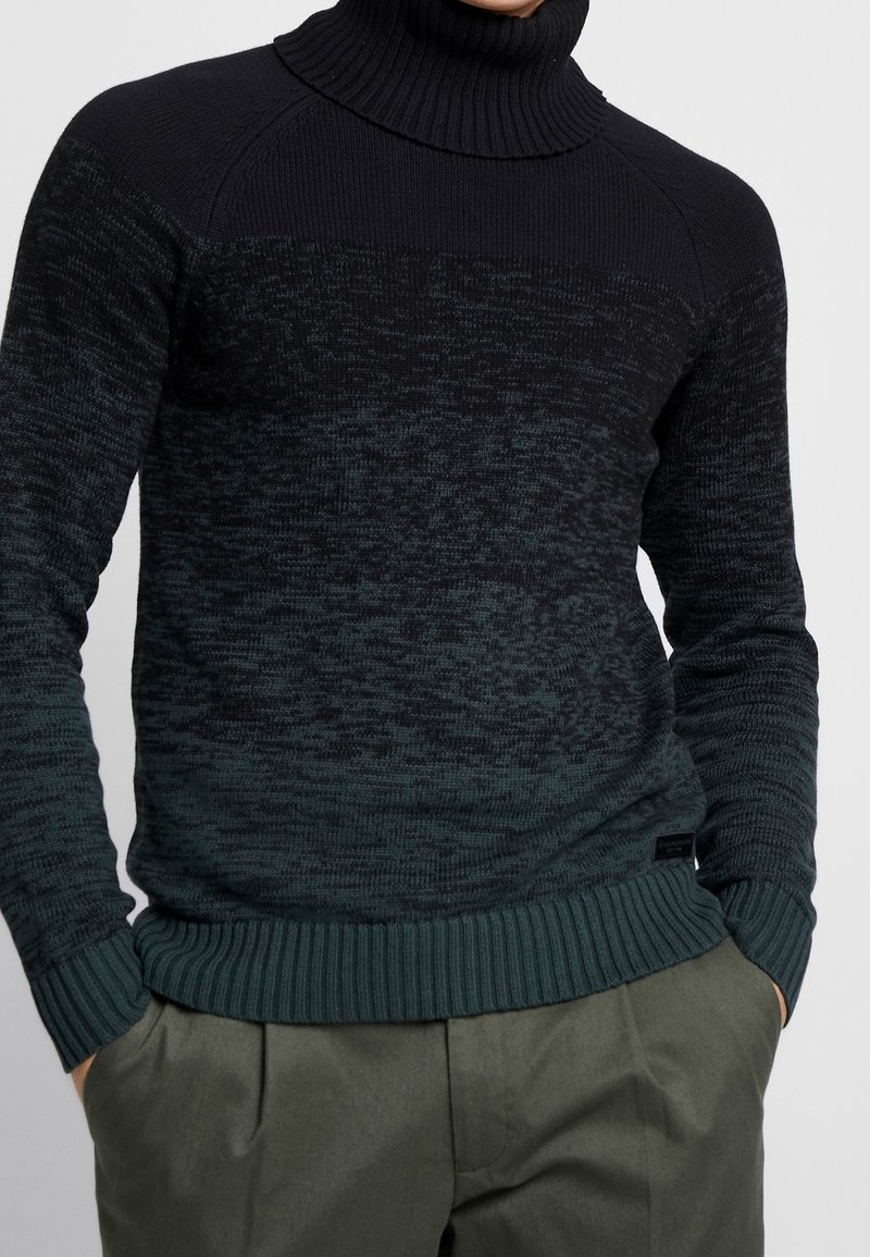 Pull à col roulé dégradé vert et noir avec poignets et ourlet côtelés, présentant un motif de tricot texturé et une coupe décontractée.