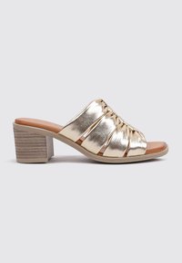 Sandalias de deslizamiento metálico dorado con tiras fruncidas, diseño de punta abierta y un tacón bloque de color claro. La planta es de color marrón claro.