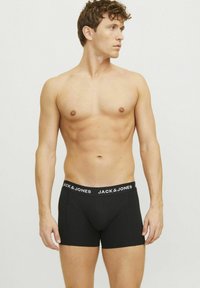 Schwarze Boxer-Briefs mit einem weißen, elastischen Bund, der das "JACK & JONES"-Logo trägt. Hergestellt aus weichem Stoff, der für Komfort und eine gute Passform sorgt.