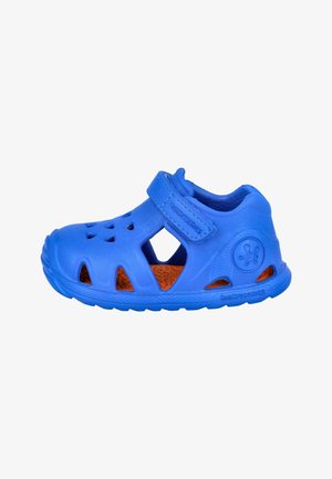 Sandalia azul para niño pequeño con correa ajustable, orificios de ventilación y plantilla naranja texturizada, diseñada para comodidad y transpirabilidad.