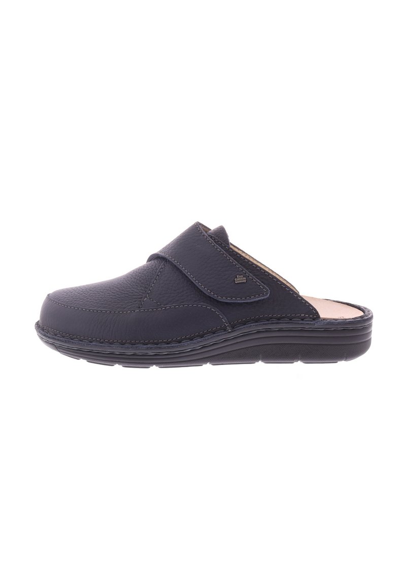 Zwarte leren instapklomp met verstelbare band en gevoerde zool, ontworpen voor comfort en ondersteuning.