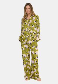 Floraler grüner Pyjama-Set mit einem langärmeligen Hemd mit Knöpfen und locker sitzender Hose, verziert mit pinken und blauen Blumenmustern.