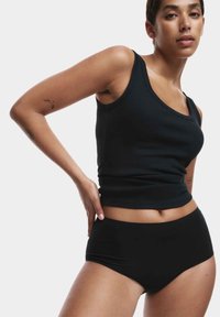 Schwarzes geripptes Tanktop mit Rundhalsausschnitt und schmaler Passform. Kombiniert mit hochgeschnittenen schwarzen Slips, glatte Textur, nahtloses Design.