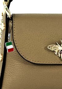 Olivenfarbener, strukturierter Lederhandtasche mit metallischem Bienenakzent und Charme der italienischen Flagge. Abgerundeter Deckel mit kontrastierender Naht.