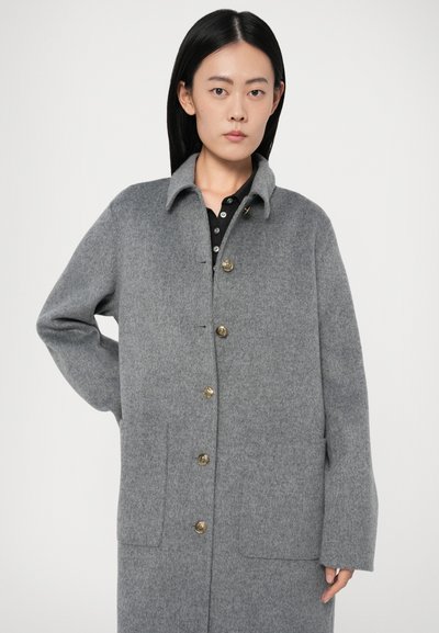 Casaco de lã cinza com gola, botões dourados e dois bolsos frontais. O tecido tem uma textura suave e um ajuste descontraído.