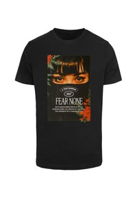 Sort bomulds T-shirt med et grafisk print af store øjne med en sort maske, omkranset af grønne planter og røde accenter, med tekst nedenfor.