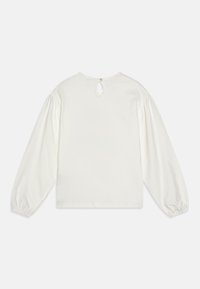 Hvid langærmet top med rund halsudskærkning, subtil nøglehulåbning bagpå og samlede pufærmer. Blødt stofkonstruktion.