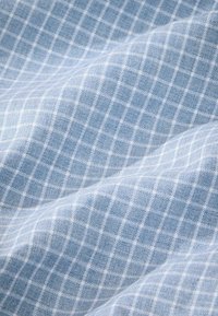 Helles blaues Gewebe mit einem karierten Muster, das kleine weiße Quadrate zeigt. Weiche Textur und leicht zerknittertes Aussehen. Durchschnittliche Dicke.
