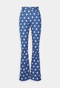 Calças azuis de boca larga em denim com um padrão de margaridas brancas, apresentando uma cintura ajustada, bolsos frontais e um fecho de correr com botão.