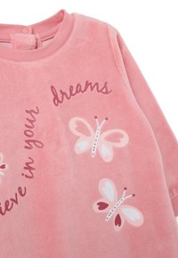 Sudadera de felpa rosa que presenta el texto "Cree en tus sueños" y mariposas decorativas con acentos en blanco, rosa y rojo.