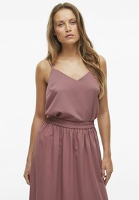 Fioletowa sukienka bez rękawów z dekoltem w kształcie litery V, marszczoną talią i miękkim, zwiewnym materiałem. Gładka tekstura z delikatnym marszczeniem.