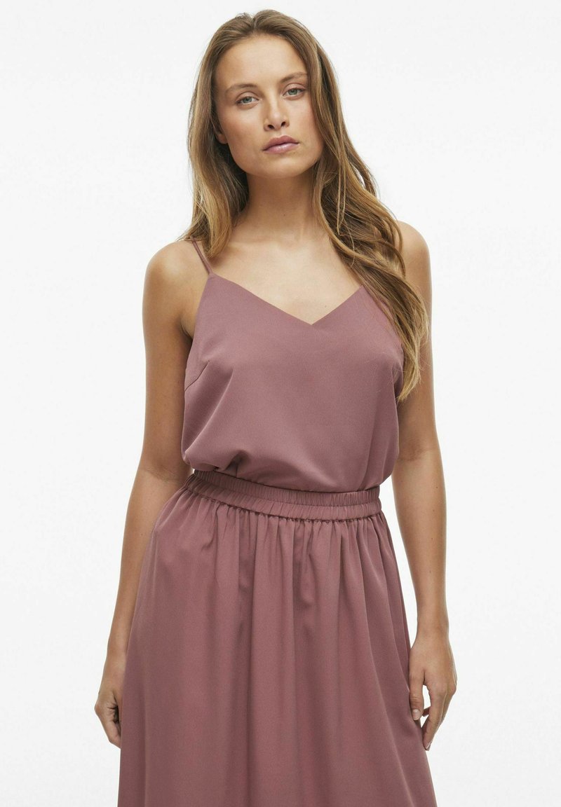 Fioletowa sukienka bez rękawów z dekoltem w kształcie litery V, marszczoną talią i miękkim, zwiewnym materiałem. Gładka tekstura z delikatnym marszczeniem.