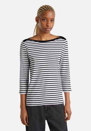 Top de manga larga a rayas en blanco y negro con un escote ancho y detalles en negro en los hombros. Tejido suave con un ajuste relajado.
