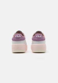 Sneakers Fila con una combinazione di colori viola e rosa, realizzati in materiali in pelle liscia e mesh, con un design della suola chunky e elevato.