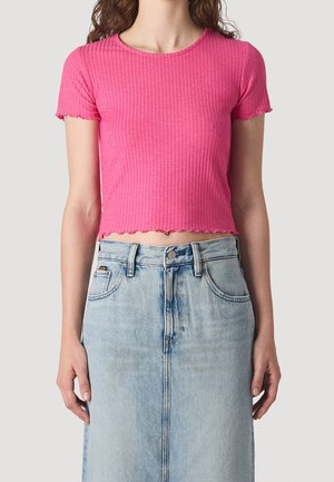 Różowy prążkowany krótki top z okrągłym dekoltem, krótkimi rękawami i falowanym dołem, zestawiony z jasnoniebieską spódnicą jeansową z zapięciem na guziki z przodu.