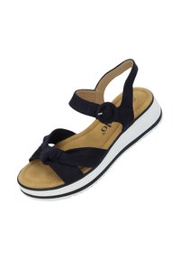 Sandal navy con correas anudadas, correa ajustable en el tobillo, plantilla beige suave y suela de plataforma blanca con un borde exterior negro.