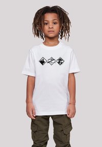 White cotton t-shirt with short sleeves, featuring three black geometric graphics across the chest. Worn with olive green cargo pants.