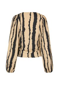 Beige top featuring black vertical stripes, long puffed sleeves, and a round neckline, with a textured fabric and gathered detailing at the waist.