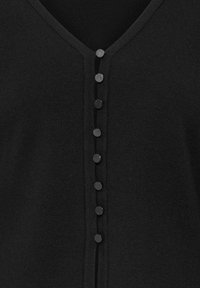 Cardigan noir en maille avec un col en V et une rangée verticale de sept boutons ronds noirs au centre devant.