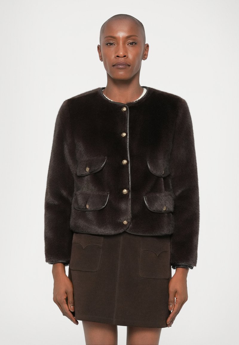 Brun kunstig pelsjakke med rund hals, gullknappfeste og to frontlommer; parret med et brunsuede skjørt.