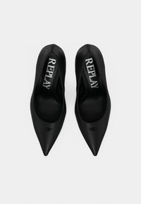 Μαύρα σατέν ψηλοτάκουνα παπούτσια με μυτερές μύτες, διακοσμημένα με δίχρωμο λογότυπο και σχεδιασμό τύπου slip-on. Ομαλή υφή και κλασική σιλουέτα.