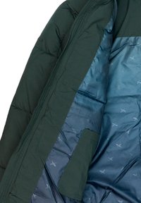 Giacca a vento verde con un rivestimento interno in satin teal liscio, dotata di una tasca e texture trapuntata. L'interno presenta un motivo sottile.