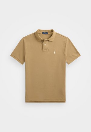 Polo en coton couleur beige avec un col, une patte de boutonnage à deux boutons, des manches courtes et un petit logo brodé blanc sur la poitrine.