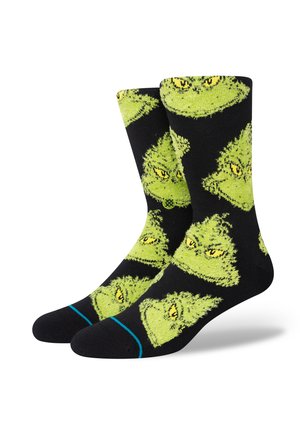 Calzini neri con un motivo ripetuto di facce del Grinch verdi con occhi gialli. Include accentuazioni blu sul polsino. Materiale in maglia morbida.