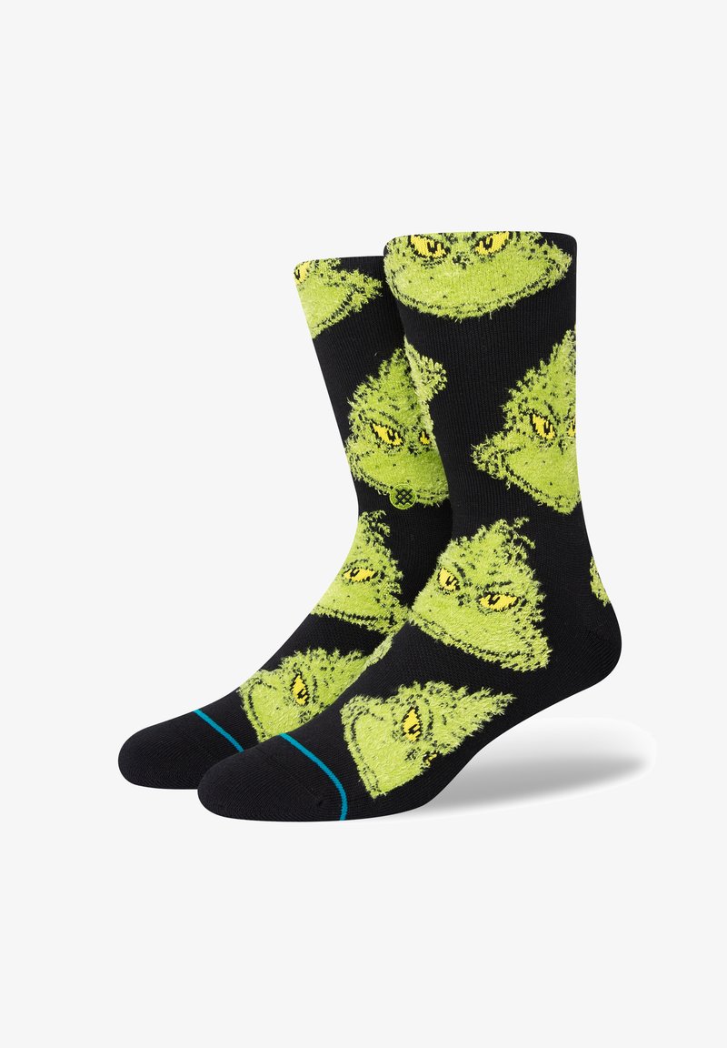 Calzini neri con un motivo ripetuto di facce del Grinch verdi con occhi gialli. Include accentuazioni blu sul polsino. Materiale in maglia morbida.