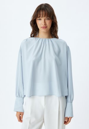 Helleblaue Seidenbluse mit gerafftem Ausschnitt, langen Puffärmeln und elastischen Bündchen, die einen entspannten Schnitt und eine glatte Textur aufweist.
