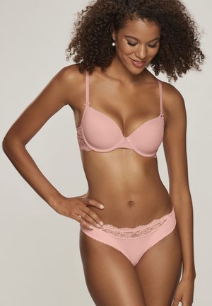 Light pink lace-trimmed bra and matching brief set made of smooth fabric, featuring underwire support and decorative bows on straps.