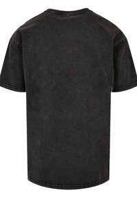 Black cotton T-shirt with a relaxed fit, short sleeves, a round neckline, and visible stitching detail along the edges.