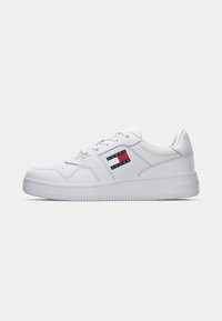 Baskets blanches en cuir avec design à lacets et logo Tommy Jeans sur le côté, semelle plate et col rembourré pour plus de confort.