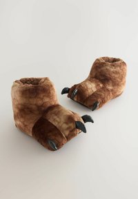 Braune Plüschhausschuhe, die wie Tierpfoten mit schwarzen Krallen gestaltet sind, auf einem schlichten hellen Hintergrund.