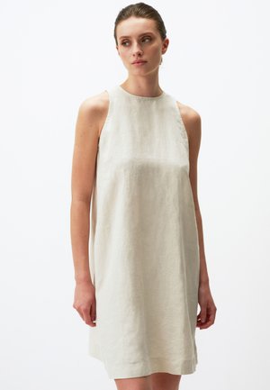 Abito senza maniche in lino di un leggero beige, dal fit rilassato, scollatura tonda e design minimalista. Tessuto morbido, lunghezza al ginocchio.