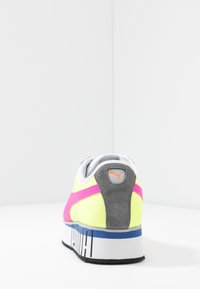 Sportovní obuv se žlutým a šedým designem, s růžovým pruhem, šedými semišovými akcenty a modrou podrážkou s černým nápisem.