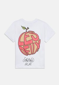 Weißes Baumwoll-T-Shirt mit einem großen, bunten Grafik eines Apfels und dem Text "LES DEUX" in fetter Schrift sowie einer stilisierten Unterschrift darunter.