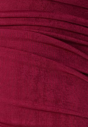 Burgunderfarbener gerippter Stoff mit einer weichen Textur, der ein gerafftes Design aufweist, das wellenförmige Linien über die Oberfläche erzeugt.