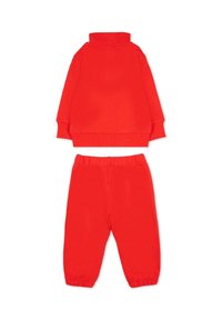 Rode katoenen trainingspak met een top met lange mouwen en een hoge kraag, en bijpassende broek met elastische tailleband en gerimpelde boorden.