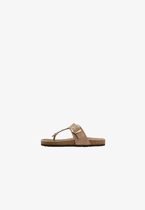 Sandalia de tiras de ante beige con suela de corcho y una gran hebilla dorada en la correa ajustable.