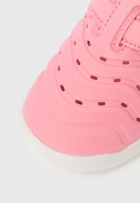 Ροζ παπούτσι με λεία υφή, που διαθέτει κυματιστά �σχέδια, οπές αερισμού και λευκή λαστιχένια σόλα.