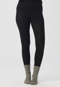 Sorte leggings laget av et lett materiale, med en tettsittende design. Par med grå, teksturerte, strikkede sokker med ribbestrikket mansjett.