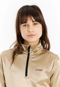 Gouden rits trui met een hoge kraag, voorzien van een zwarte rits en een klein zwart logo op de borst. Glad, glanzend materiaal met een aansluitend design.