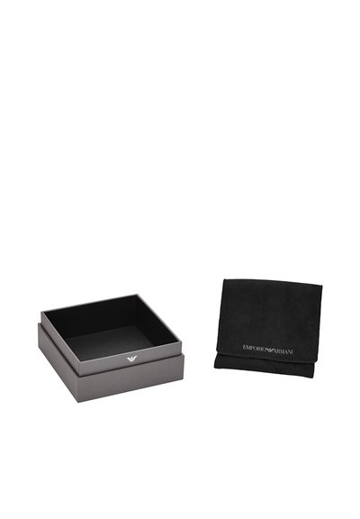 Caja de cartón gris con un acabado mate suave y un logo. Junto a ella, una bolsa de ante negra con texto blanco está doblada.