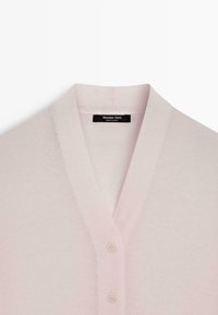 Cardigan rose clair avec col en V, fabriqué en matériau doux, avec deux boutons assortis sur le devant et une étiquette à l'intérieur.