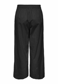 Pantalon court noir avec une taille élastique, présentant des motifs floraux découpés le long de l'ourlet et un tissu lisse et léger.